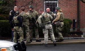 A Swat team prepares to enter St Rose of Lima Roman Catholic Church in Newtown