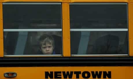 A child looks out of a bus window as it passes by Saint Rose of Lima Church where the funeral of James Mattioli, 6 is taking place in Newtown, Connecticut. Most children in Newtown returned to classes for the first time since last week's massacre, but survivors of the shooting stayed at home and their school remained a crime scene.