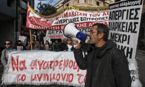 epa03514088 Municipality workers hold banners and shout slogans as they march in central Athens on 19 December 2012.