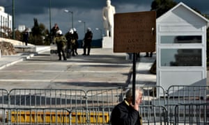 An demonstrator holding a banner passes in front of a blocked entrance of the Greek Parliament in Athens on December 19, 2012, as Public services in Greece are hit by a 24-hour strike called by unions in protest at damage to the sector caused by sweeping austerity measures.