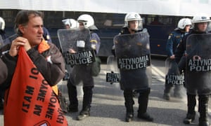 A protester stands in front of riot police during a demonstration in Athens.