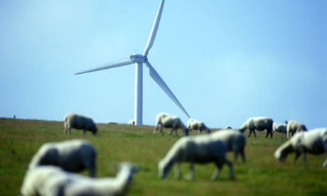 A wind turbine towers over grazing sheep in South Wales