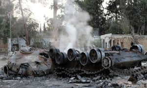Smoke rises from a burnt tank belonging to government forces in the Damascus suburb of Douma.