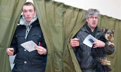 Two men leave polling booths in Latvia