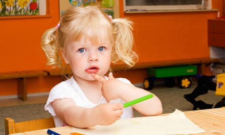 Blond little girl, 2 years, sitting at table with crayons