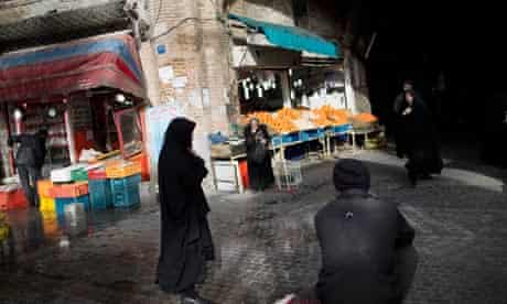 Iranian women walk near a central Tehran bazaar