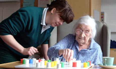 A nurse plays solitaire with a patient in a hospital ward