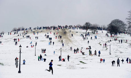 People play in the snow on Primrose Hill in north London