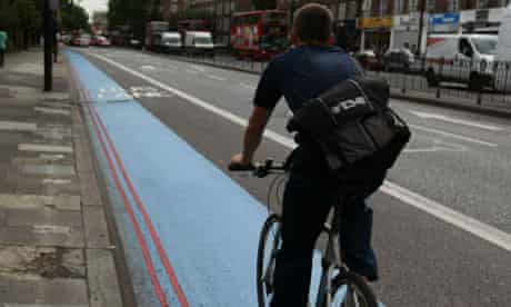 A cyclist on a blue bike lane in west London