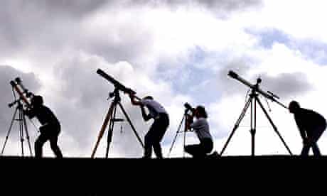 PEOPLE LOOKING THROUGH TELESCOPES
