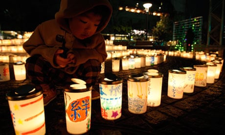 Japan disaster anniversary: a boy lights a candle at a memorial service in Koriyama