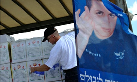 Noam Shalit places a sticker on goods aboard a truck