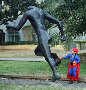 Readers' pictures: Young boy in a superman costume stood by a statue
