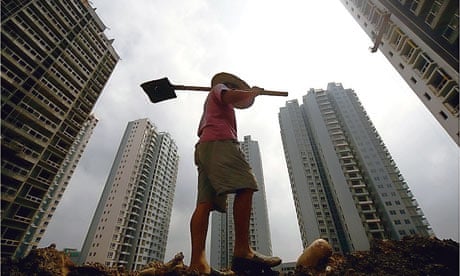 A Chinese manual worker surrounded by skyscrapers in Suining