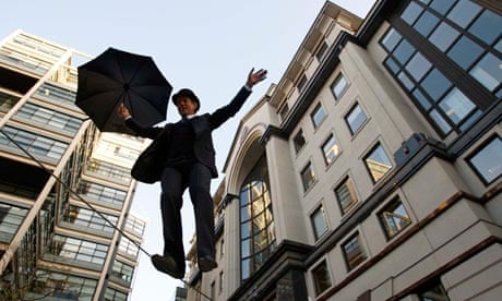 A man dressed as a city gentleman walks across a tightrope in London's financial district