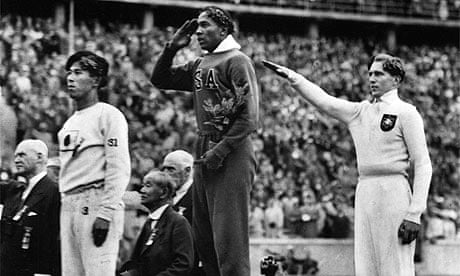 American Jesse Owens salutes during the long jump medal ceremony at the Berlin Olympics