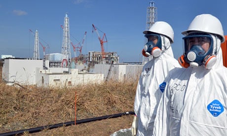 Fukushima Daiichi workers stand near the nuclear power plant during a press tour in February 2012