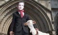 A demonstrator wears a Jeremy Hunt mask while holding a goat named Adam Smith