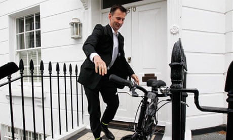 Jeremy Hunt hops on bicycle outside London home
