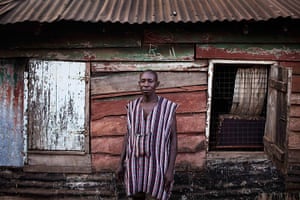 Sierra Leone Architecture: Man infront of his grandmother's colonial-era Board House in the Congo Town