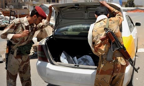 Yemeni soldiers search a car