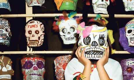 Mexican girl wearing a skull mask for the Day of the Dead
