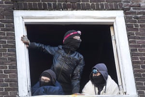Picture desk live: Squatters stand in the window 