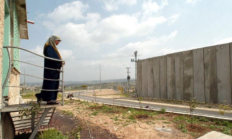A Palestinian woman looks at the Israeli 'security fence' 