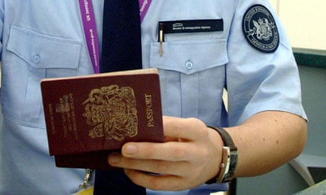 An immigration officer checks a passport at Terminal 1 at Heathrow airport