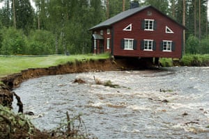 A Longer View - Flooding: TOPSHOTS A house hangs over a rain-swoll