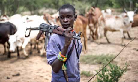 Korinamba Ruto, 14, herds cattle in Kenya's Rift valley with a gun for protection against rustlers