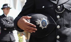 Metropolitan police officer holds his helmet