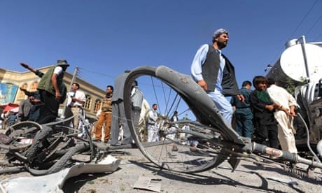 Afghan locals inspect the site of a bicycle bomb explosion in Herat