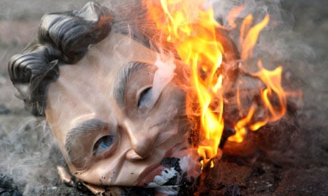 A mask of former British Prime Minister, Tony Blair, is burned outside the Iraq inquiry