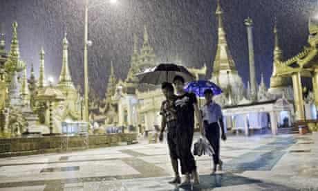 Burmese men walk in the rain in Rangoon