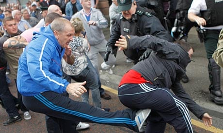 A police officer tries to stop fighting between loyalist and nationalist groups in Belfast