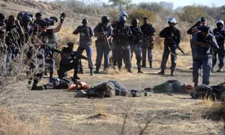 South African police gather around fallen miners on 16 August