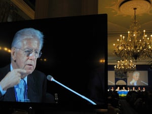 Italy's Prime Minister Mario Monti (R) is seen on a large screen during the Ambrosetti workshop, an international economic meeting, in Cernobbio, September 9, 2012. 