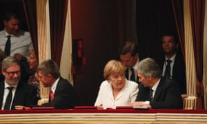 Austrian Chancellor Werner Faymann (R) and German Chancellor Angela Merkel wait for the beginning of Guiseppe Verdi's opera Don Carlo in their loge in the State Opera house in Vienna September 7, 2012