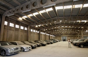 Greece scrapyard: A man walks by confiscated luxury cars inside a warehouse 