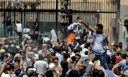 A Yemeni protester burns a US flag as others storm the US embassy in Sana'a during a protest against a film deemed insulting to the Prophet Mohammed.