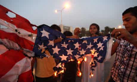 Followers of the Ansar al-Sharia brigade burn a US flag outside the Tibesti hotel in Benghazi, Libya