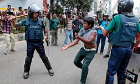 Bangladeshi policeman detain an activist from an Islamic group at a protest in Dhaka