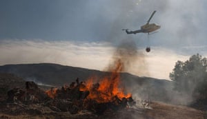 24 hours in pictures: A helicopter flies over a burning fire