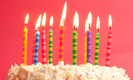 birthday cake with lots of cute striped candles shot on a red background