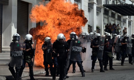 A fire bomb explodes behind a riot police squad on September 26, 2012 in Athens during clashes with demonstrators at a 24-hours general strike. 