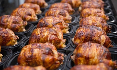 Cooked rotisserie chickens are displayed for sale