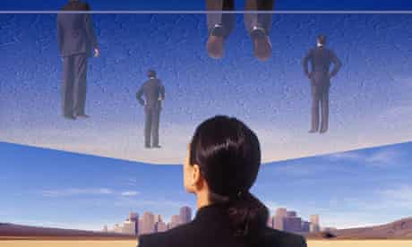 Businesswoman looking at glass ceiling