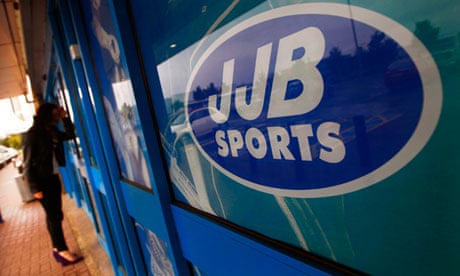 A woman looks in the window of a closed-down JJB Sports store in Edinburgh, Scotland