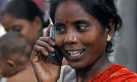 Indian slum dweller uses mobile phone in Kolkata